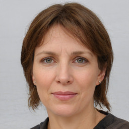 Joyful white adult female with medium  brown hair and grey eyes