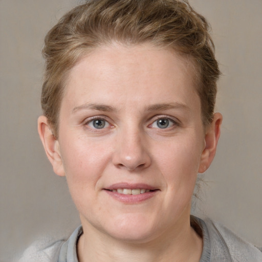 Joyful white young-adult female with short  brown hair and blue eyes