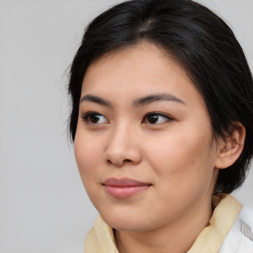 Joyful asian young-adult female with medium  brown hair and brown eyes