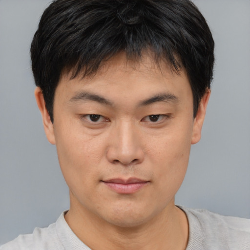 Joyful asian young-adult male with short  brown hair and brown eyes