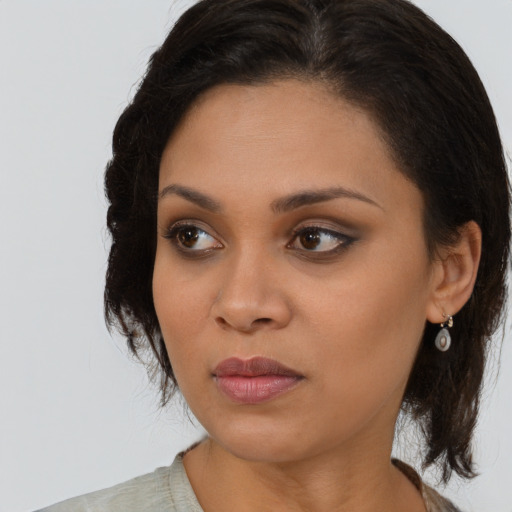 Joyful black young-adult female with medium  brown hair and brown eyes