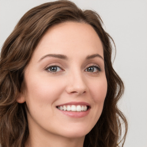 Joyful white young-adult female with long  brown hair and green eyes