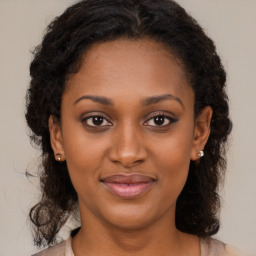 Joyful black young-adult female with medium  brown hair and brown eyes