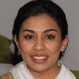 Joyful latino young-adult female with medium  brown hair and brown eyes