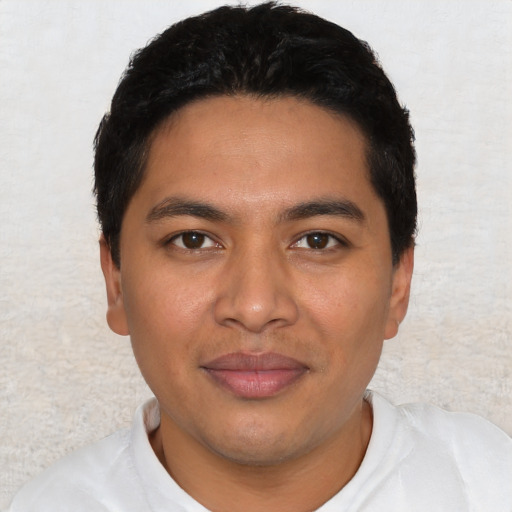 Joyful latino young-adult male with short  black hair and brown eyes