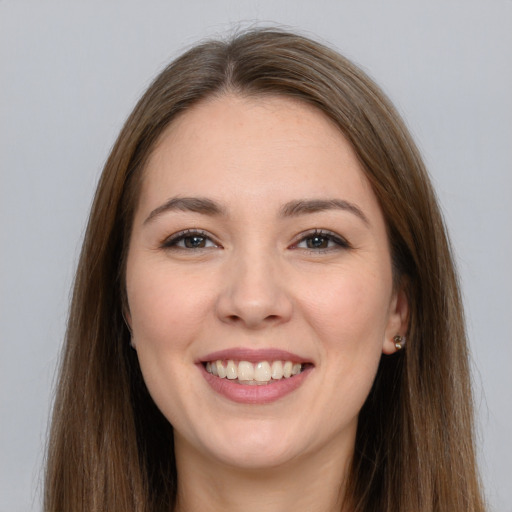 Joyful white young-adult female with long  brown hair and brown eyes