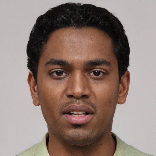Joyful black young-adult male with short  black hair and brown eyes