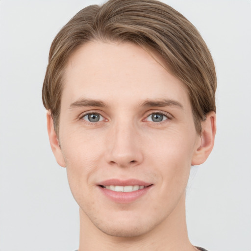 Joyful white young-adult male with short  brown hair and grey eyes