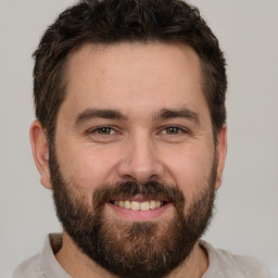 Joyful white adult male with short  brown hair and brown eyes