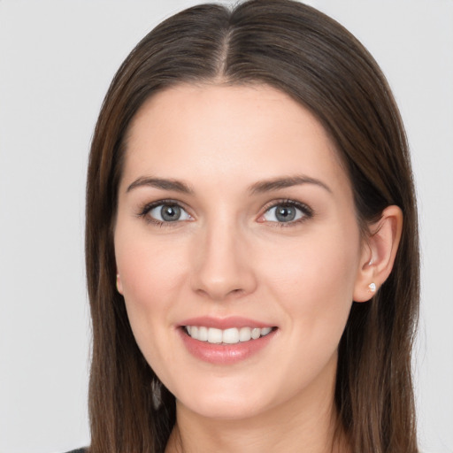 Joyful white young-adult female with long  brown hair and brown eyes