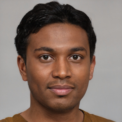 Joyful black young-adult male with short  brown hair and brown eyes