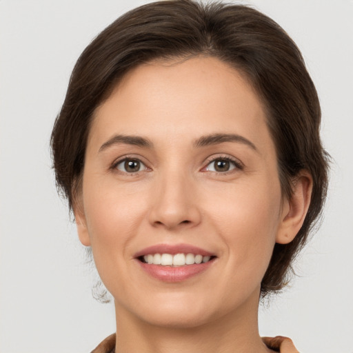 Joyful white young-adult female with medium  brown hair and brown eyes