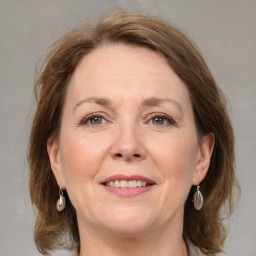 Joyful white adult female with medium  brown hair and grey eyes