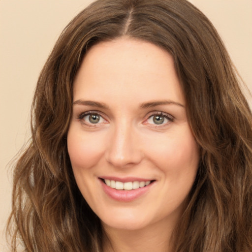 Joyful white young-adult female with long  brown hair and green eyes