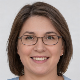 Joyful white adult female with medium  brown hair and grey eyes