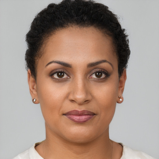 Joyful black young-adult female with short  brown hair and brown eyes