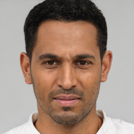 Joyful white young-adult male with short  black hair and brown eyes