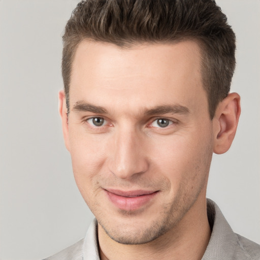 Joyful white young-adult male with short  brown hair and grey eyes