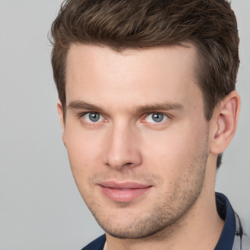 Joyful white young-adult male with short  brown hair and grey eyes