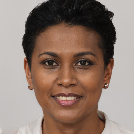 Joyful black young-adult female with short  black hair and brown eyes