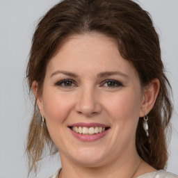 Joyful white young-adult female with medium  brown hair and grey eyes