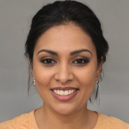 Joyful latino young-adult female with medium  brown hair and brown eyes