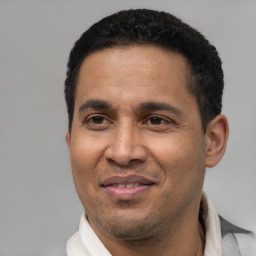 Joyful latino young-adult male with short  black hair and brown eyes