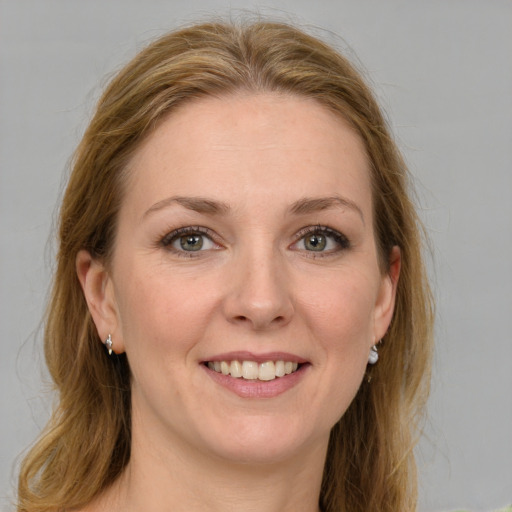 Joyful white young-adult female with medium  brown hair and green eyes