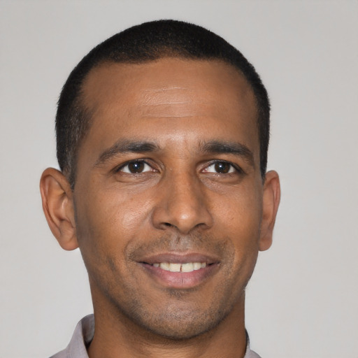 Joyful black young-adult male with short  black hair and brown eyes
