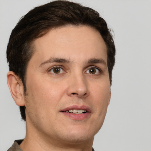 Joyful white young-adult male with short  brown hair and grey eyes