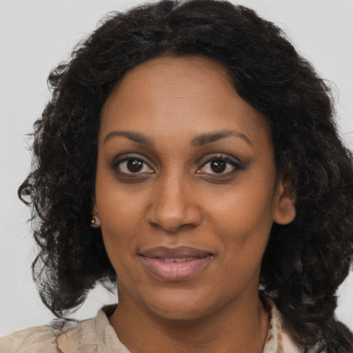 Joyful black young-adult female with long  brown hair and brown eyes
