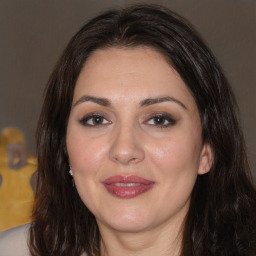 Joyful white adult female with long  brown hair and brown eyes