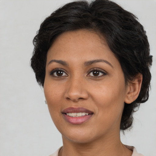 Joyful latino adult female with medium  brown hair and brown eyes