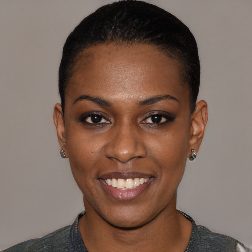 Joyful black young-adult female with short  black hair and brown eyes