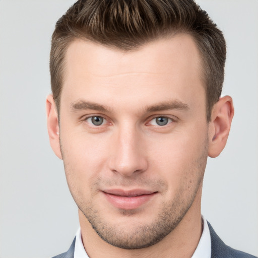 Joyful white young-adult male with short  brown hair and grey eyes