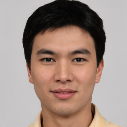 Joyful asian young-adult male with short  black hair and brown eyes