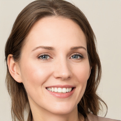 Joyful white young-adult female with long  brown hair and grey eyes