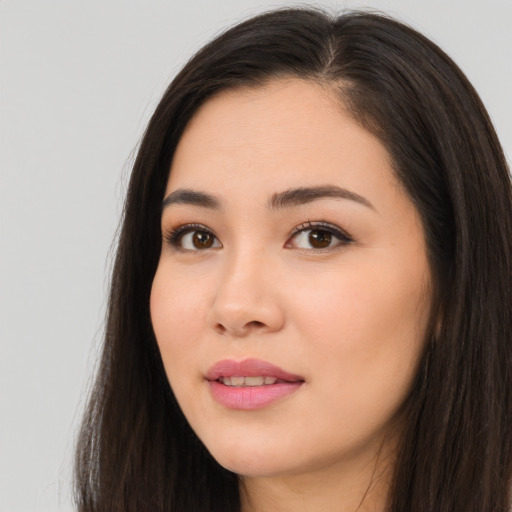 Joyful asian young-adult female with long  brown hair and brown eyes