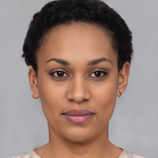Joyful black young-adult female with short  black hair and brown eyes