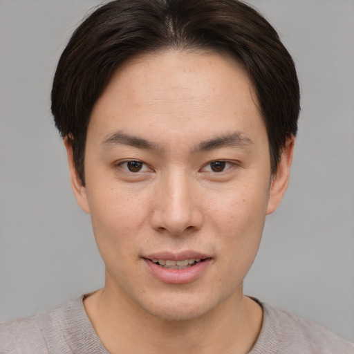 Joyful asian young-adult male with short  brown hair and brown eyes