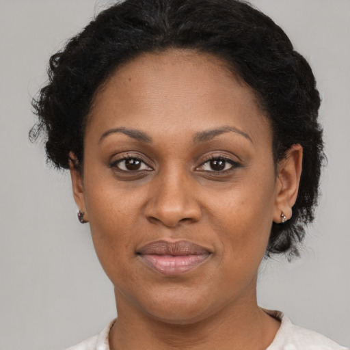 Joyful black adult female with short  brown hair and brown eyes