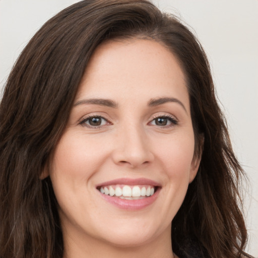 Joyful white young-adult female with long  brown hair and brown eyes