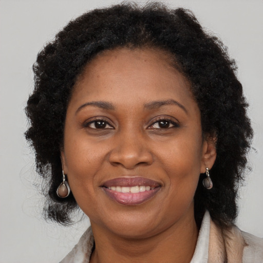 Joyful black adult female with long  brown hair and brown eyes