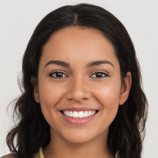 Joyful latino young-adult female with long  brown hair and brown eyes