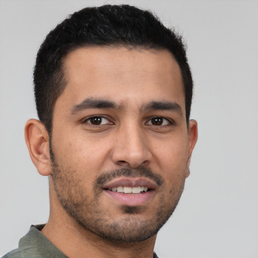 Joyful latino young-adult male with short  brown hair and brown eyes