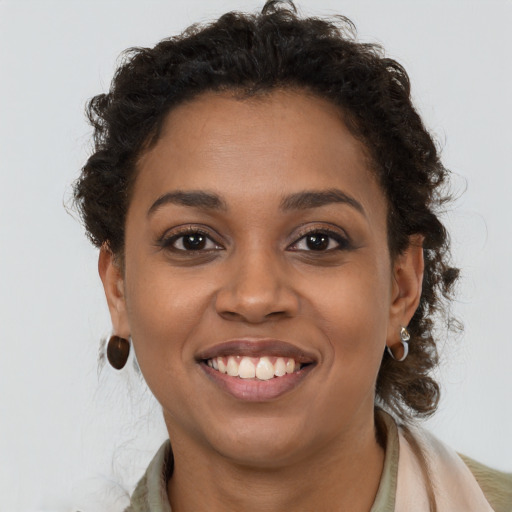 Joyful black young-adult female with long  brown hair and brown eyes