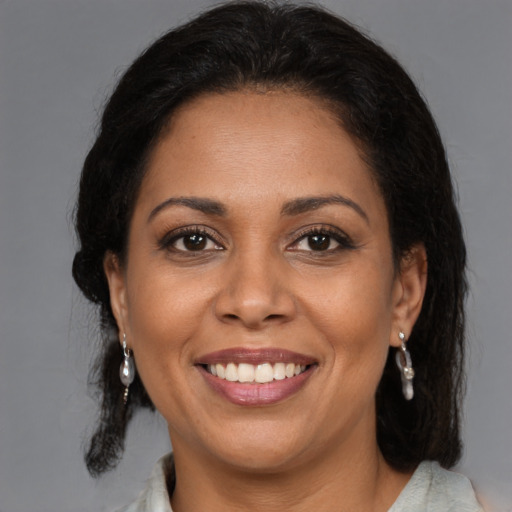 Joyful latino adult female with medium  brown hair and brown eyes