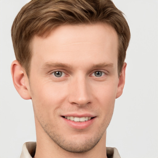 Joyful white young-adult male with short  brown hair and grey eyes