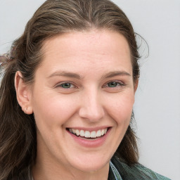 Joyful white young-adult female with long  brown hair and blue eyes