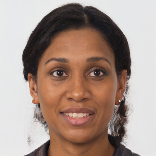 Joyful black adult female with medium  brown hair and brown eyes